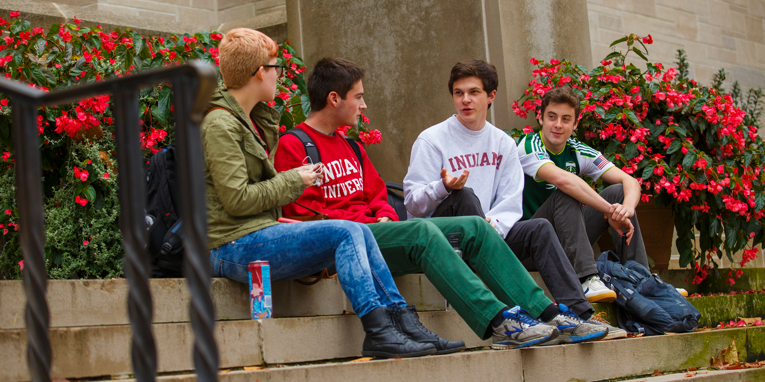Students sit on stair steps holding conversation